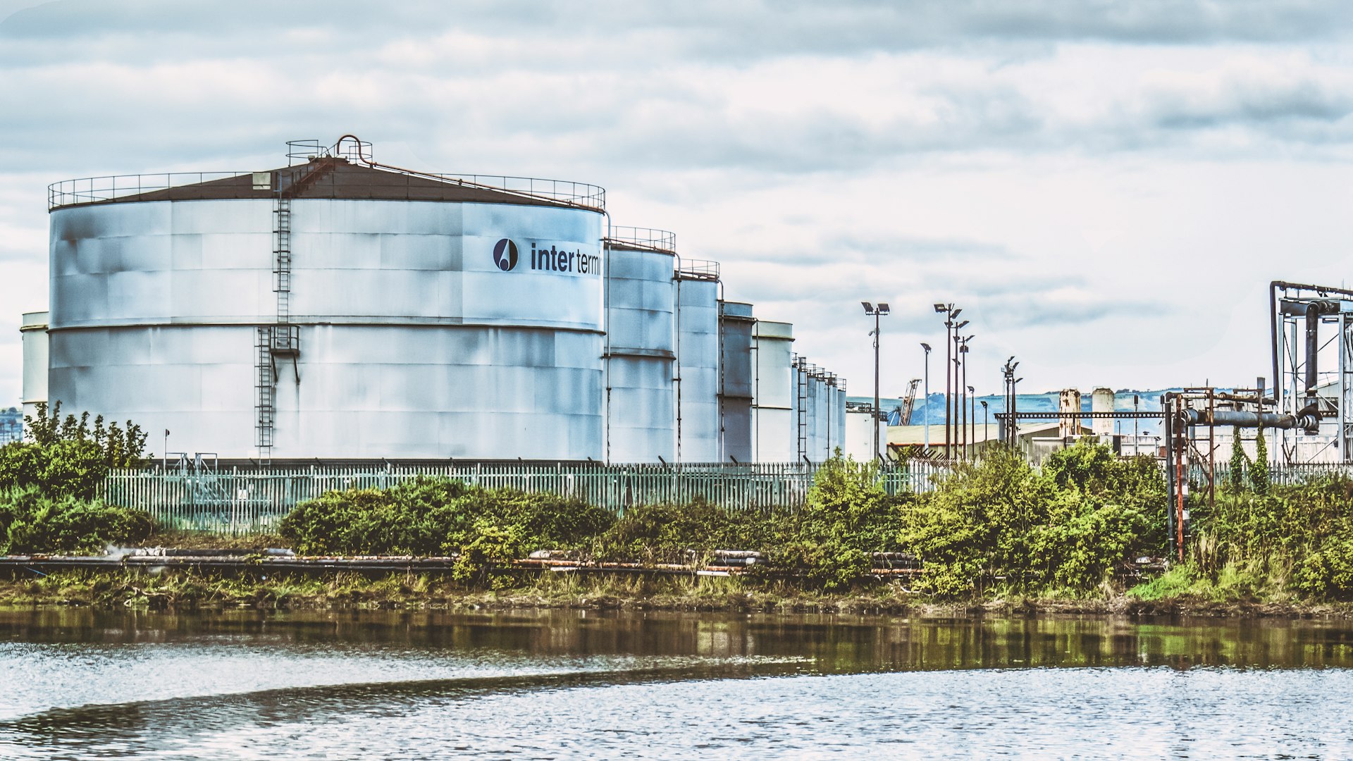 a large industrial building next to a body of water